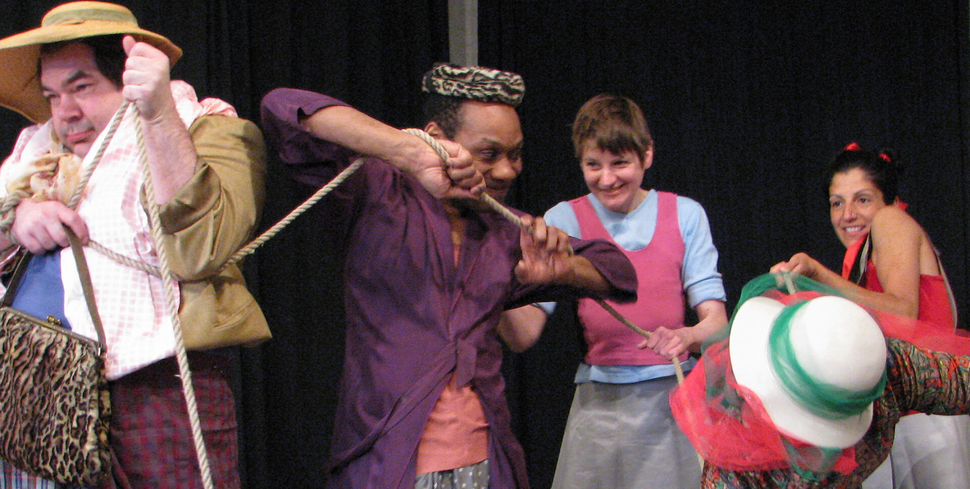 Szenenfoto einer Auffuehrung: Vier Personen nebeneinander auf einer Bühne
